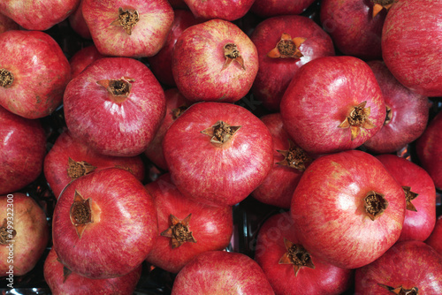 Juicy and ripe pomegranate whole with flower. Ruby natural garnet fruit. High quality photo.