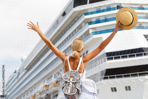 Woman tourist standing in front of big cruise liner, travel female