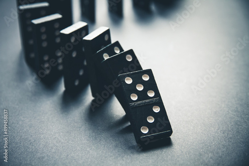 Black dominoes chain on table background