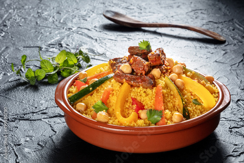 Meat and vegetable couscous in a bowl, typical food from Morocco, a traditional festive Arabic dish with herbs and spices