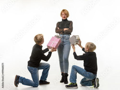 Children give a gift to mom while kneeling