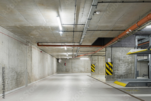 Garaż podziemny z miejscami parkingowymi. Ściany garażu wykonane z betonu. Parking na platformie. Oszczędność miejsc parkingowych