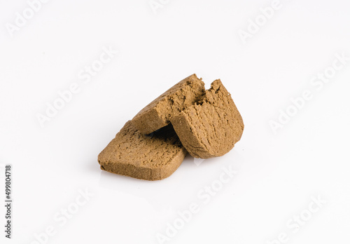 Two marijuana cannabis pollen hashish on a white background.