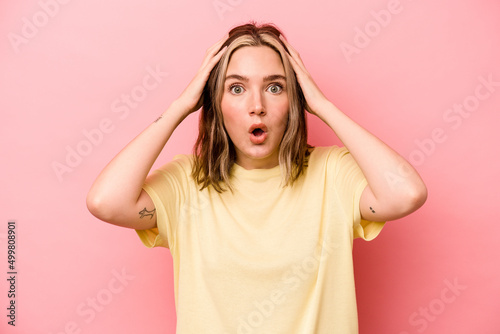 Young caucasian woman isolated on pink background being shocked, she has remembered important meeting.