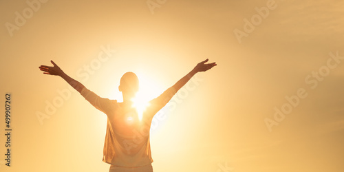 Feelings of hope light. Female lifting her arms up to the golden sky 