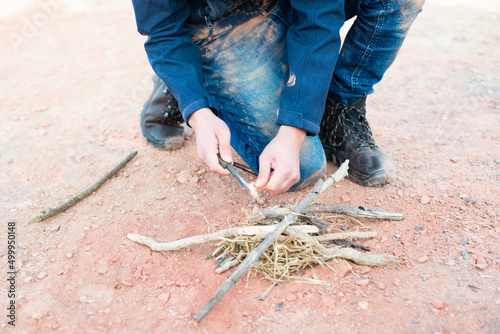 Starting a fire with a firesteel, survival and adventure equipment, outdoor skill, man making a campfire 