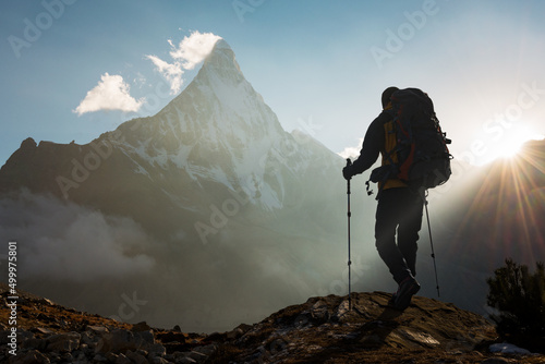 Mountain Man with backpack hiking in the mountains at sunset