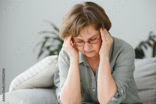 health care, pain, stress, age and people concept - face of senior woman suffering from headache