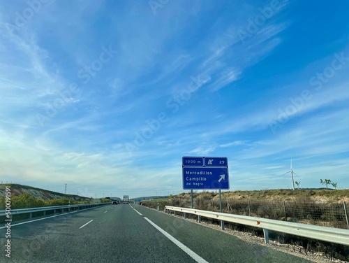 Spanish highway A3 in Castile La Mancha, windmills in the background.