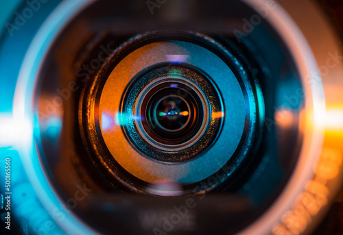 Video camera lens lit by blue and orange color light