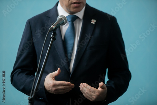 Press conference with media microphones held in front of business man, spokesman or politician