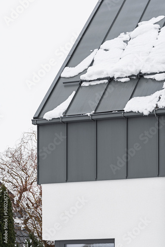 Detal architektoniczny na budynek, dom jednorodzinny. Dach wykonany z blachy aluminiowej w kolorze szarym