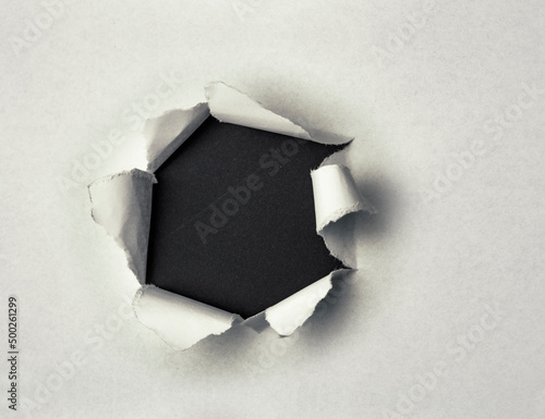Loch in einem Papierblatt mit weissem Hintergrund