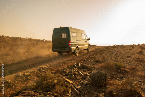 4x4 camper van going up a dusty road at sunset