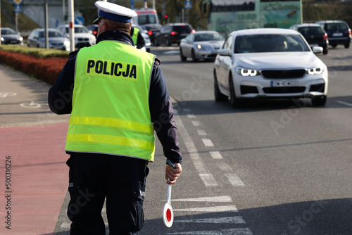  Policjant policji drogowej podczas kierowania ruchem z lizakiem do zatrzymywania pojazdów.