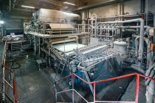 Paper production machine in wastepaper recycling factory. Paper and pulp mill.
