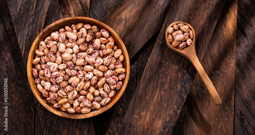 Phaseolus vulgaris - Dried pinto beans in the bowl and wooden spoon
