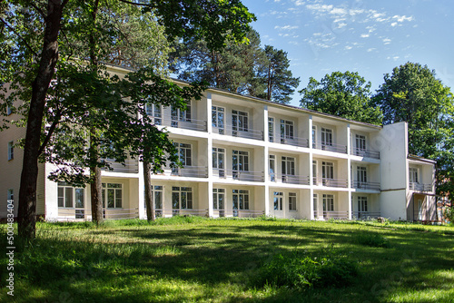 A typical three-story building of a sanatorium near Moscow with balconies on the river bank