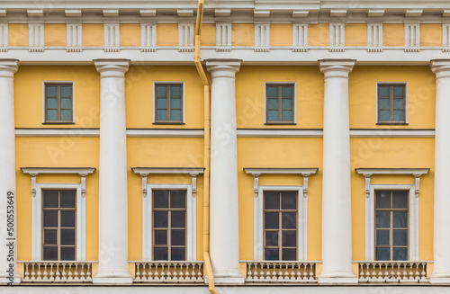 Columns and several windows in a row on the facade of the urban historic apartment building front view, Saint Petersburg, Russia 