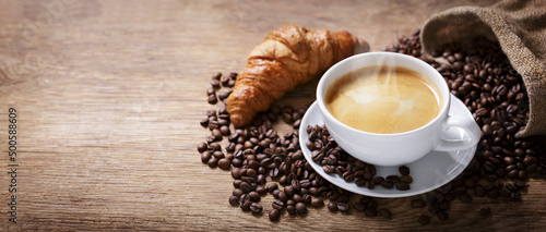 cup of coffee, croissant and coffee beans
