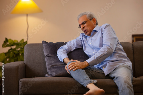 Portrait of a senior man suffering from knee pain 