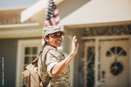 Happy servicewoman waving her hand on her homecoming