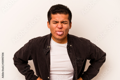 Young hispanic man isolated on white background funny and friendly sticking out tongue.