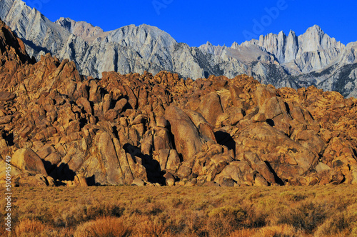 Early morning light on the rock formations of the Alabama Hills National Scenic Area, Mount Whitney and other neighbouring peaks, Lone Pine, Eastern Sierra, California