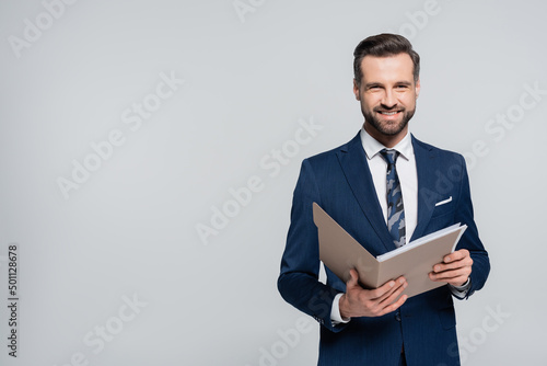 happy economist with folder smiling at camera isolated on grey.