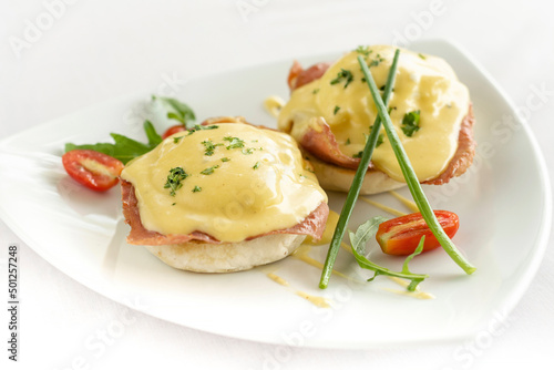 eggs benedict breakfast with ham and hollandaise sauce