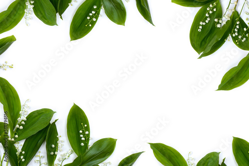 White flowers Lily of the valley ( Convallaria majalis, May bells, may lily ) with green leaves on a white background with space for text. Top view, flat lay