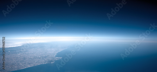 Aerial view of glowing edge between earth and sky