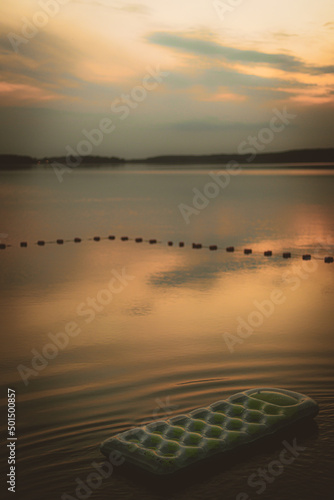 sunset on the beach, zachód słońca nad jeziorem, spokojna woda i materac dmuchany.