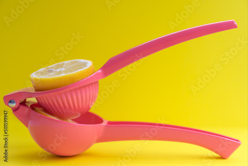 Squeezing a lemon with a pink lemon squeezer