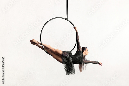 Flexible woman doing exercise on aerial hoop
