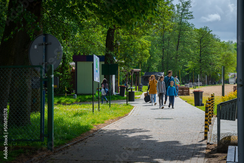 rodzina spaceruje po alejce w parku wiosną