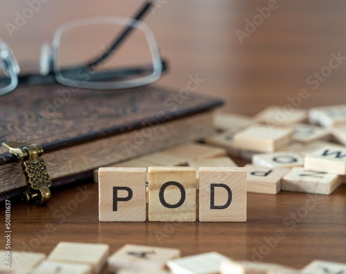 the acronym pod for payable on death word or concept represented by wooden letter tiles on a wooden table with glasses and a book