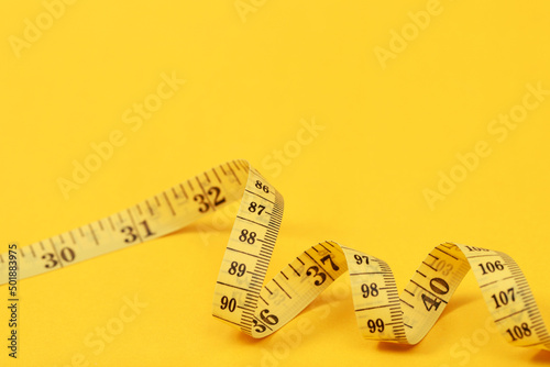 tape measure for obese people on a yellow background soft focus