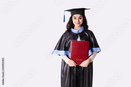 University graduate wearing academic regalia with red diploma. Background with copy space.