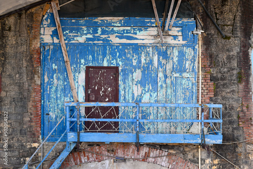 Close-up of an old boathouse with peeling blue wall and a wooden ladder, Nervi, Genoa, Liguria, Italy