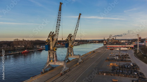 Port cranes at the port channel in Gdansk at sunset.