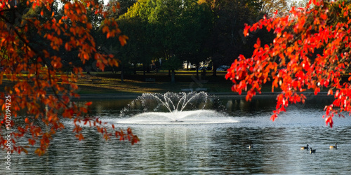 Small fountain in a lake framed by autumn foliage