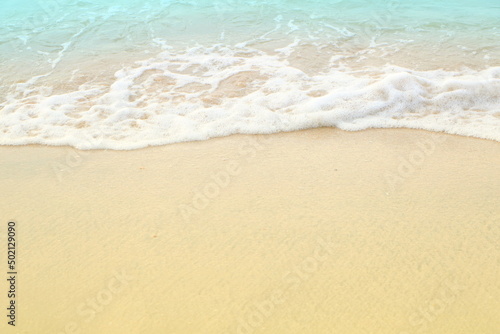 Soft white blue sea wave on clean brown sandy beach coast have copyspace