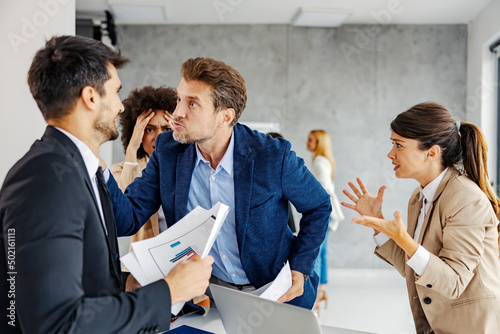 An angry businessman threatening his colleague in the office.