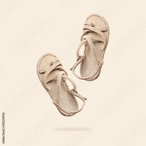 Summer female wicker sandals isolated on beige background. Fashionable trendy rope straw sandals. Jute slippers. Handmade Eco-friendly natural shoes. Cut out objects for design, Mock up