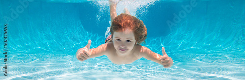 Child swimming underwater with thumbs up. Underwater kid swim under water. Child boy swimming and diving underwater in pool. Banner for header, copy space. Poster for web design.