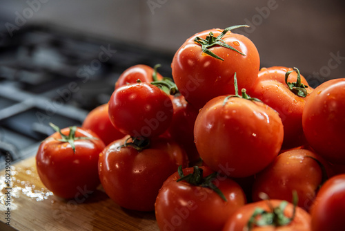 Umyte błyszczące pomidory w kuchni na desce do krojenia