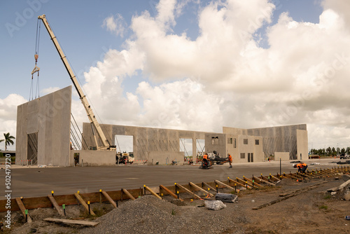 Workmen completing the foundations of a tilt-up warehouse being constructed of prefabricated concrete panels.