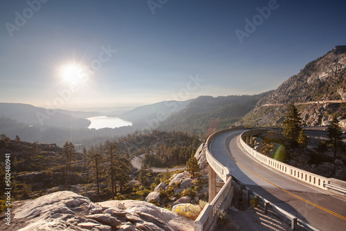 Curvy mountain road with bridge and lake