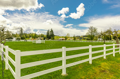 Typical white wooden fence in farmland. Spring in rural area.